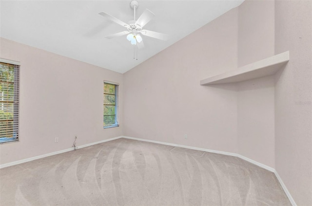 empty room with vaulted ceiling, a ceiling fan, baseboards, and light carpet