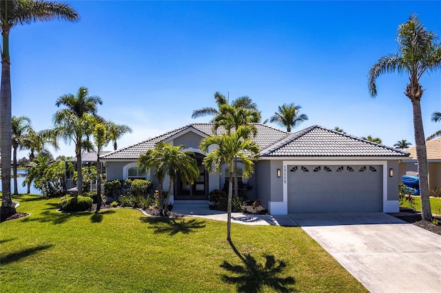 view of front facade featuring an attached garage, a front lawn, a tile roof, stucco siding, and driveway