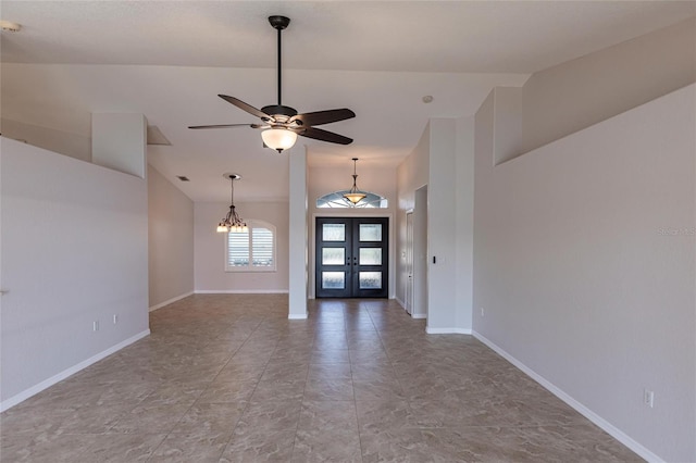 foyer entrance featuring french doors, baseboards, ceiling fan with notable chandelier, and vaulted ceiling