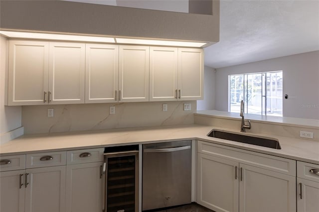 kitchen with light stone counters, a sink, wine cooler, white cabinets, and dishwasher