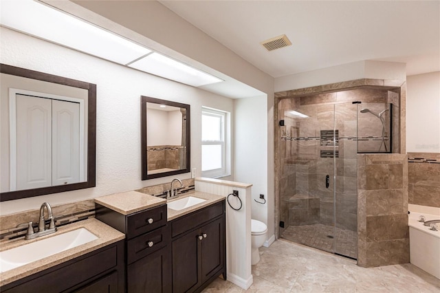 bathroom with vanity, visible vents, a shower stall, a garden tub, and toilet