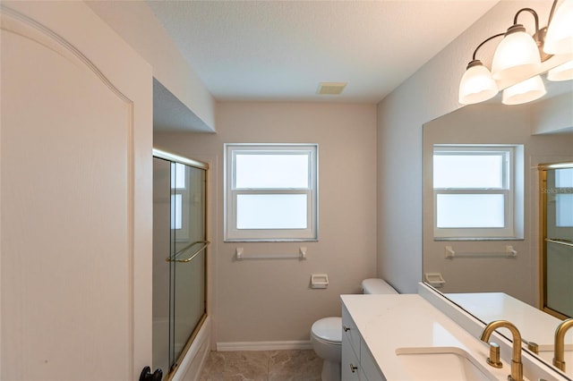 bathroom featuring vanity, toilet, baseboards, and a wealth of natural light