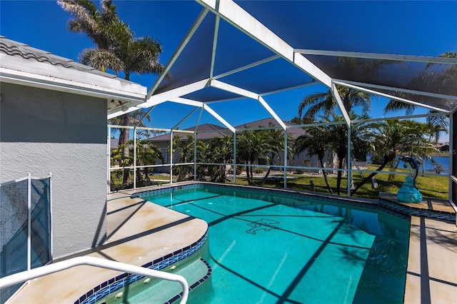 outdoor pool featuring glass enclosure and a patio area