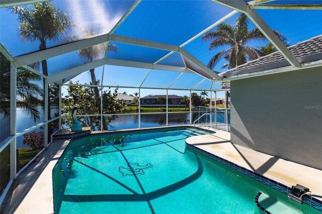 outdoor pool with a lanai, a patio area, and a water view