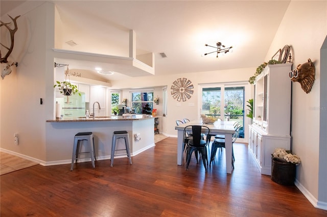 dining area featuring visible vents, baseboards, dark wood-type flooring, and lofted ceiling