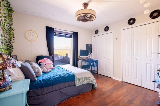 bedroom with wood finished floors and multiple closets