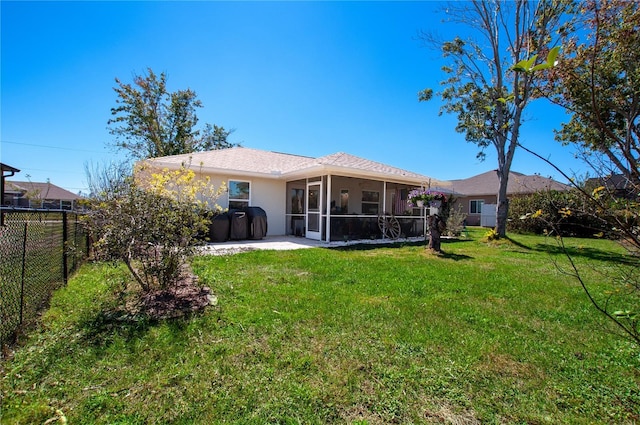 back of property featuring stucco siding, a lawn, a fenced backyard, and a sunroom