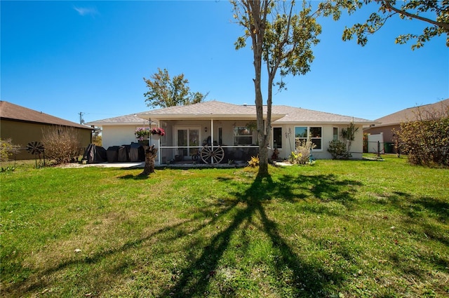 back of property featuring a yard, fence, and stucco siding