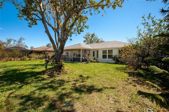 rear view of property with a yard and a sunroom