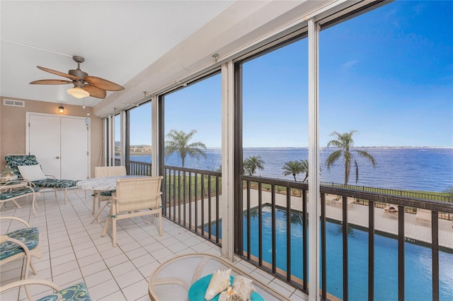 sunroom / solarium with visible vents, ceiling fan, and a water view