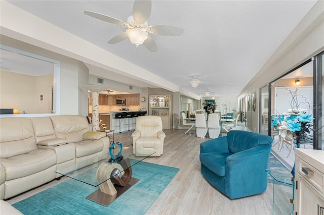 living room with visible vents, ceiling fan, and light wood-style floors