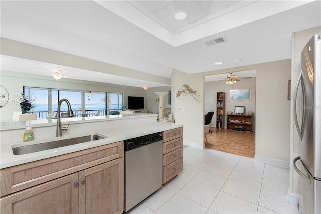 kitchen with visible vents, light countertops, light tile patterned floors, stainless steel appliances, and a sink