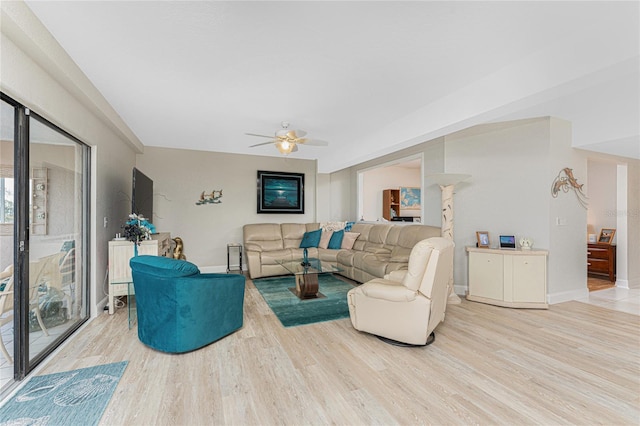 living area featuring ceiling fan, baseboards, and wood finished floors