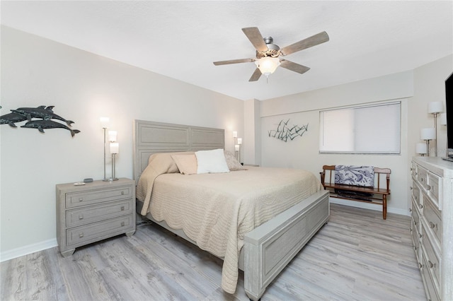 bedroom with ceiling fan, baseboards, and light wood-style floors