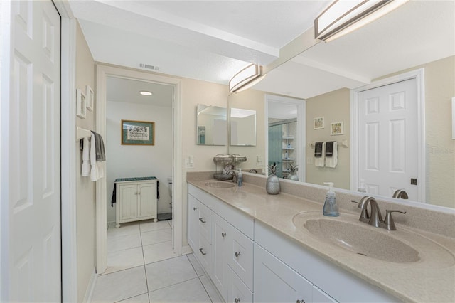 full bathroom featuring tile patterned flooring, double vanity, visible vents, and a sink