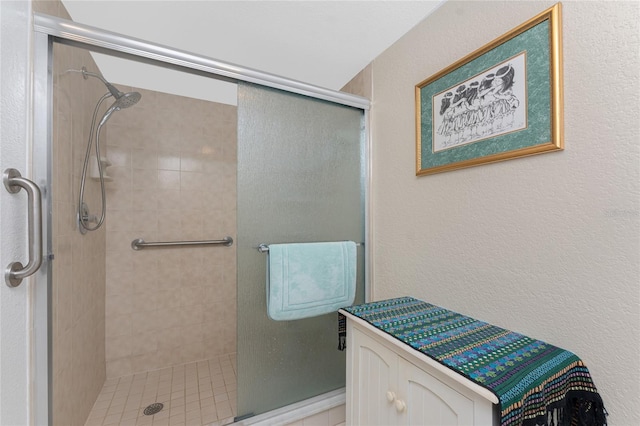 bathroom featuring a textured wall and a stall shower