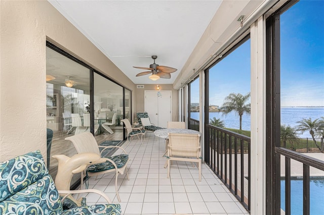 sunroom / solarium featuring a ceiling fan, visible vents, and a water view