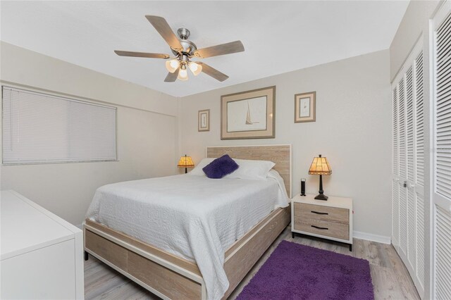 bedroom with a closet, baseboards, ceiling fan, and wood finished floors