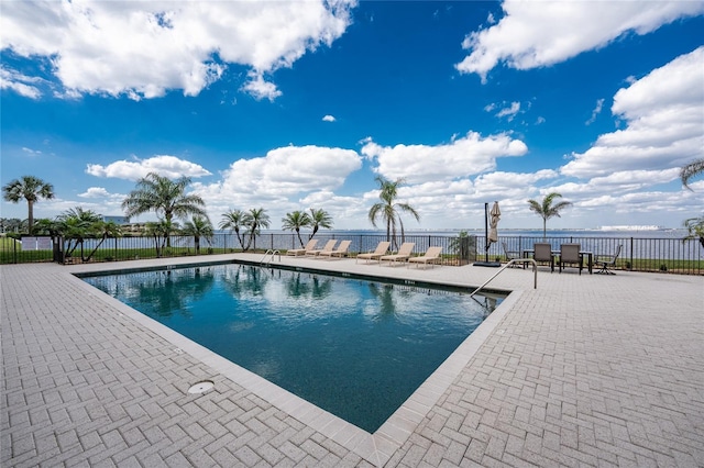 community pool with a patio and fence