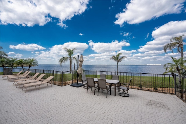 view of patio / terrace featuring fence and a water view