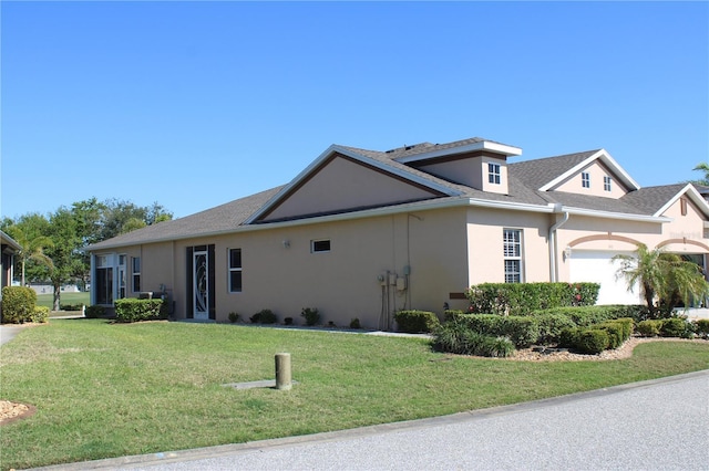 ranch-style house featuring a front yard, a garage, and stucco siding