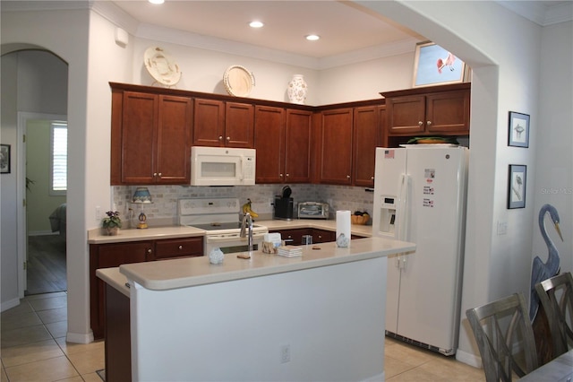 kitchen with white appliances, arched walkways, and backsplash