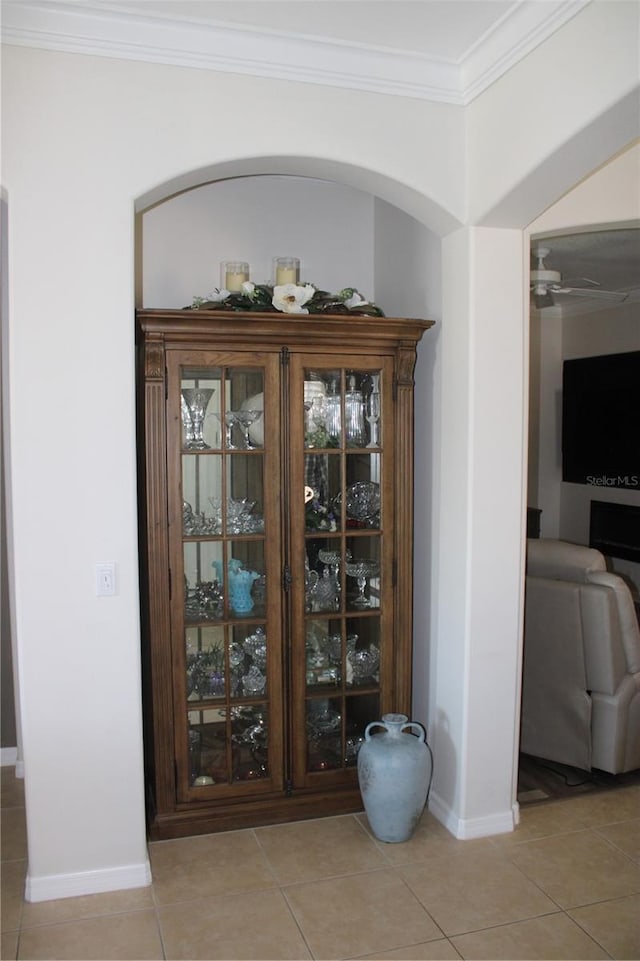 room details featuring crown molding, a ceiling fan, and baseboards