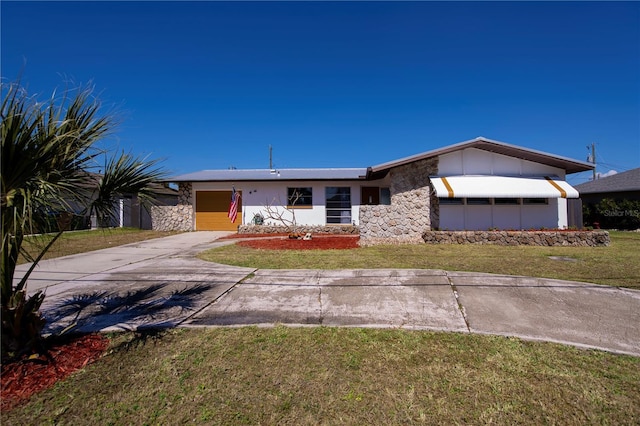 view of front of house with concrete driveway, a garage, stone siding, and a front lawn