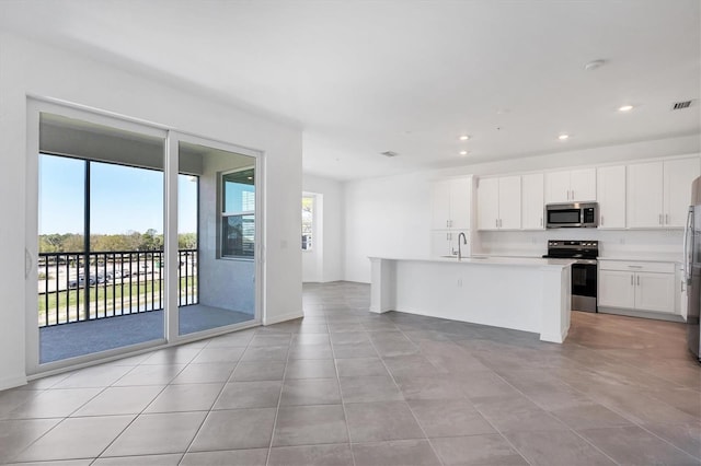 kitchen featuring an island with sink, recessed lighting, light countertops, white cabinets, and appliances with stainless steel finishes