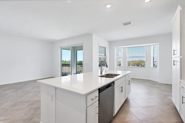 kitchen with visible vents, plenty of natural light, a kitchen island with sink, a sink, and stainless steel dishwasher