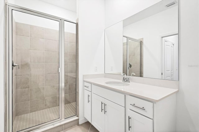 bathroom with vanity, a shower stall, visible vents, and tile patterned floors