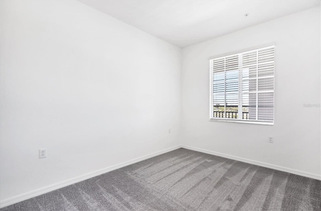 carpeted empty room with baseboards