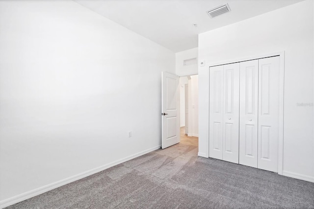 unfurnished bedroom featuring a closet, visible vents, carpet flooring, and baseboards