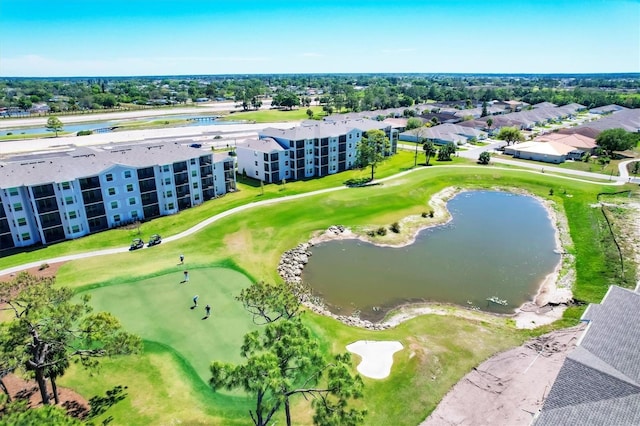 drone / aerial view with view of golf course and a water view