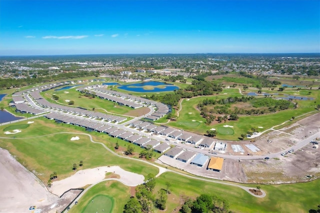 birds eye view of property with golf course view and a water view