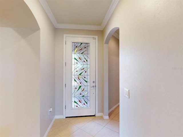 entrance foyer featuring arched walkways, light tile patterned flooring, baseboards, and ornamental molding