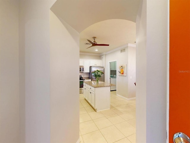 kitchen with visible vents, a ceiling fan, washer / clothes dryer, stainless steel appliances, and light tile patterned floors