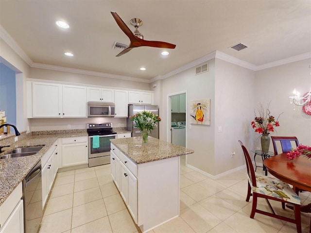 kitchen with visible vents, washer and dryer, stainless steel appliances, and a sink