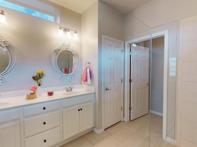 bathroom featuring tile patterned floors, double vanity, baseboards, and a sink