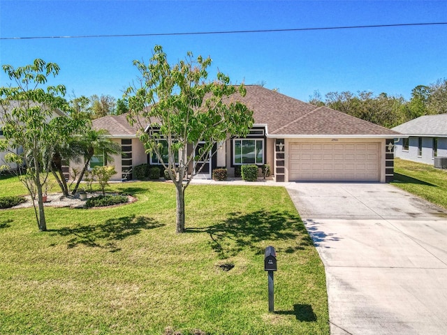 ranch-style home featuring an attached garage, a front lawn, central air condition unit, stucco siding, and driveway