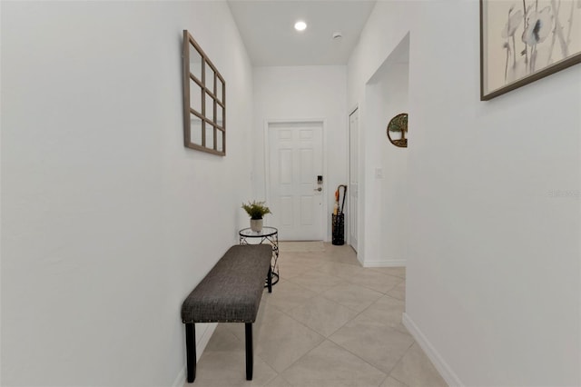 corridor with light tile patterned floors, baseboards, and recessed lighting