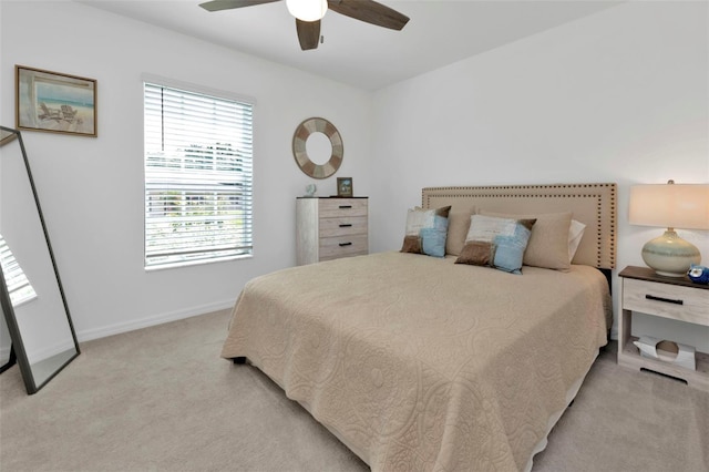 bedroom with a ceiling fan, light colored carpet, and baseboards