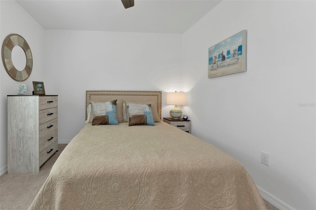 bedroom featuring baseboards, light colored carpet, and a ceiling fan