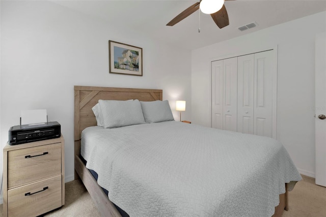 bedroom with visible vents, baseboards, ceiling fan, light colored carpet, and a closet