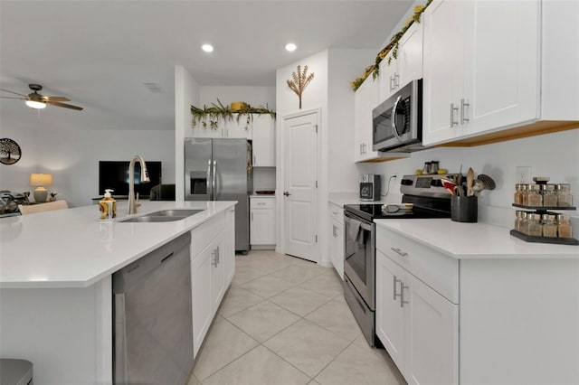 kitchen featuring light tile patterned floors, stainless steel appliances, white cabinets, and light countertops