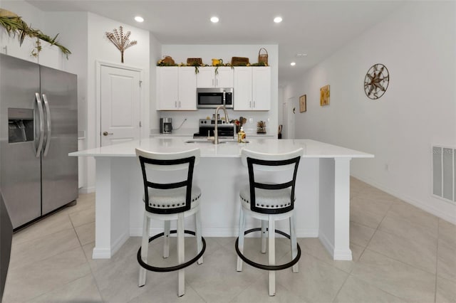 kitchen with visible vents, a breakfast bar, recessed lighting, appliances with stainless steel finishes, and light countertops