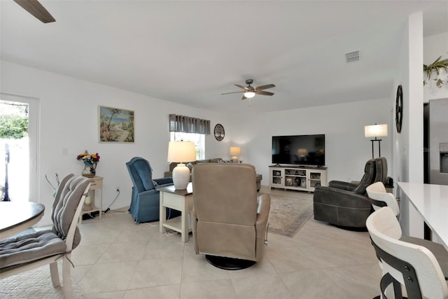 living area featuring light tile patterned flooring, visible vents, and ceiling fan