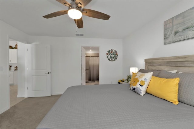 carpeted bedroom featuring visible vents, connected bathroom, baseboards, and a ceiling fan