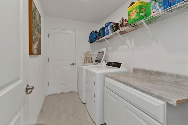 clothes washing area with light tile patterned flooring, washing machine and dryer, and laundry area