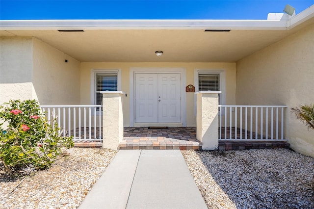 doorway to property featuring stucco siding